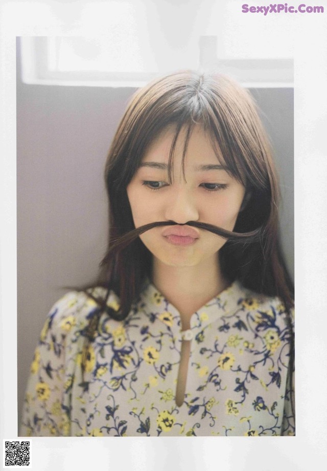 A woman with a fake moustache on her face.