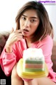 A woman sitting on a couch eating a piece of cake.