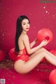 A woman in a red lingerie holding a red lantern.