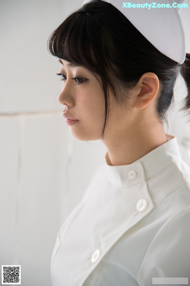 A woman in a white uniform is looking away from the camera.