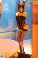 A woman in a black dress and cat ears posing for a picture.
