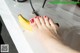 A woman's feet with red nail polish and a banana on a counter.