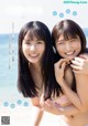 A couple of young women standing next to each other on a beach.