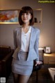 A woman in a business suit posing for a picture.