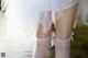 A close up of a woman's legs in white stockings.