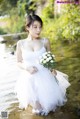 A woman in a white dress holding a bouquet of flowers.