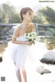 A woman in a white dress holding a bouquet of flowers.