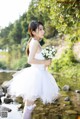 A woman in a white dress holding a bouquet of flowers.