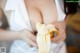 A woman holding a peeled banana in her hands.