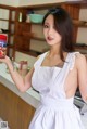 A woman in a white dress holding a can of food.