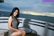 A woman in a black and white bathing suit sitting on a balcony.