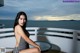 A woman in a black and white bathing suit sitting on a balcony.