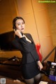 A woman in a business suit talking on a phone.