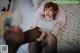 A woman sitting on top of a bed next to a stuffed animal.