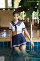 A woman in a sailor outfit standing in a pool.