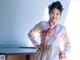 A woman in a white and pink hanbok posing for a picture.